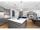 Open-concept kitchen with gray cabinetry, a center island, and access to the living room at 2110 Crigan Bluff Dr, Cary, NC 27513