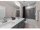 Bathroom with a double sink vanity, gray tile shower, and modern fixtures at 2609 Aster Ct, Apex, NC 27502