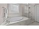 Modern bathroom featuring a soaking tub, marble surround and a glass enclosed shower at 2609 Aster Ct, Apex, NC 27502