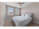 Neutral bedroom with a ceiling fan and sunlit windows showing views of the neighborhood at 2609 Aster Ct, Apex, NC 27502