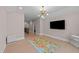 Upstairs bonus room featuring a modern light fixture and a large wall-mounted television at 2609 Aster Ct, Apex, NC 27502