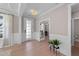 Open foyer with wood floors, white wainscotting, a decorative light fixture, and glass-paned doors at 2609 Aster Ct, Apex, NC 27502