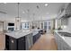 Open-concept kitchen with a large island, stainless steel appliances, and views of the living room with a fireplace at 2609 Aster Ct, Apex, NC 27502
