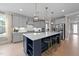 Bright and airy kitchen featuring a large island with seating, stainless steel appliances, and custom cabinetry at 2609 Aster Ct, Apex, NC 27502