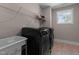 Laundry room with a sink, black front load machines, tile floor, and a window at 2609 Aster Ct, Apex, NC 27502