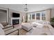 Cozy living room with a fireplace, comfortable seating, and large windows offering natural light at 2609 Aster Ct, Apex, NC 27502