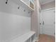 Mudroom with a white bench, coat hooks, and overhead storage at 2609 Aster Ct, Apex, NC 27502