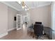 Bright office featuring coffered ceiling, a modern light fixture and white french doors at 2609 Aster Ct, Apex, NC 27502