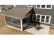 View of a screened porch and patio, with outdoor seating, and adjacent rear lawn at 2609 Aster Ct, Apex, NC 27502