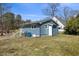Backyard view featuring lawn, a small porch, and a house with blue siding at 2611 Atlantic St, Durham, NC 27707