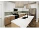 Bright kitchen featuring stainless steel appliances, two-toned cabinetry, a tile backsplash, and large center island with seating at 264 Beacon Dr, Pittsboro, NC 27312