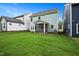 A well-maintained backyard featuring a lush green lawn, a screened-in porch, and pleasant neighborhood surroundings at 283 Beacon Dr, Pittsboro, NC 27312