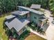 Aerial view of a green home with solar panels, attached garage and lush, mature landscaping at 295 Cedar Rock Trl, Fuquay Varina, NC 27526
