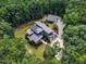 Beautiful aerial view of a modern home with a separate garage, surrounded by lush landscaping and mature trees at 295 Cedar Rock Trl, Fuquay Varina, NC 27526