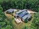 Drone shot of a lovely home with solar panels, patio, and lush landscaping, perfect for energy-efficient living and outdoor enjoyment at 295 Cedar Rock Trl, Fuquay Varina, NC 27526