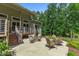 Back patio featuring elegant lounge furniture with stairs leading to the upper, screened-in, covered deck at 295 Cedar Rock Trl, Fuquay Varina, NC 27526