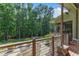 Spacious deck overlooking a lush backyard with modern railings and stone accents, providing an ideal outdoor living space at 295 Cedar Rock Trl, Fuquay Varina, NC 27526