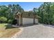 Detached two-car garage with matching architecture to the main house surrounded by lush landscaping at 295 Cedar Rock Trl, Fuquay Varina, NC 27526