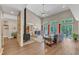 Open-concept living area with a stone fireplace, wood floors, large windows, and access to an outdoor deck at 295 Cedar Rock Trl, Fuquay Varina, NC 27526