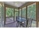Relaxing screened-in porch with ceiling fan and views of the surrounding trees, ideal for enjoying the outdoors bug-free at 295 Cedar Rock Trl, Fuquay Varina, NC 27526