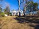 Home featuring a spacious yard and mature trees, showcasing a serene and picturesque setting at 298 E Salisbury St, Pittsboro, NC 27312