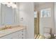 Bright bathroom featuring a glass shower, a vanity, and a white toilet next to a window at 302 Edinburgh Dr, Cary, NC 27511