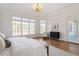Spacious bedroom with large windows, hardwood floors, and a cozy seating area at 302 Edinburgh Dr, Cary, NC 27511