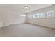 Expansive bonus room with neutral carpet, white walls, recessed lighting, and multiple windows at 302 Edinburgh Dr, Cary, NC 27511