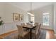 Formal dining room with wainscoting, hardwood floors, modern light fixture, and seating for six at 302 Edinburgh Dr, Cary, NC 27511