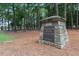 Stone entrance sign for MacGregor Downs Country Club, set among towering trees at 302 Edinburgh Dr, Cary, NC 27511