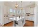 Gourmet kitchen with a center island, white cabinetry, and modern lighting fixtures at 302 Edinburgh Dr, Cary, NC 27511