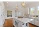Open kitchen with large island, hardwood floors, and white cabinets with modern appliances at 302 Edinburgh Dr, Cary, NC 27511