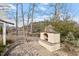 Stone outdoor kitchen area and brick-laid patio with a view of the lake behind the property at 302 Edinburgh Dr, Cary, NC 27511