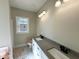 Bathroom featuring dual sinks, a window, and light colored walls and floors at 314 S Darden St, Kenly, NC 27542