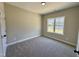 Bedroom with neutral walls, plush carpet, one window, and white trim and doors at 314 S Darden St, Kenly, NC 27542