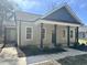 Close-up of a cozy home with a covered front porch, showcasing the neutral siding and dark accent columns at 314 S Darden St, Kenly, NC 27542
