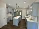 Bright kitchen featuring a central island, gray cabinets, white counter tops, and hardwood style floor at 314 S Darden St, Kenly, NC 27542