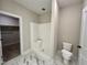 Bathroom showcasing a shower, toilet, and a walk-in closet with shelves at 315 S Maple Ave, Kenly, NC 27542