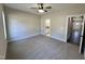 Neutral bedroom with a ceiling fan and doorways to bathroom and hall at 315 S Maple Ave, Kenly, NC 27542