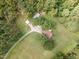 Aerial view of a sprawling estate with a long driveway leading to the residence surrounded by lush greenery at 4322 Russell Rd, Graham, NC 27253