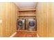 Laundry room featuring front load washer and dryer, wooden walls and wooden shelving at 4322 Russell Rd, Graham, NC 27253
