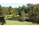 The pond is surrounded by greenery, enhancing the estate's privacy and natural beauty at 4322 Russell Rd, Graham, NC 27253