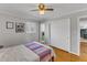 This bedroom has light-colored walls, a wood floor, a ceiling fan, and a door to a small bathroom at 503 Sherwood Dr, Sanford, NC 27330