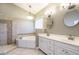 Bathroom featuring double vanities, a soaking tub, tiled shower, and neutral decor at 5508 Lake Edge Dr, Holly Springs, NC 27540