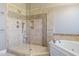 Modern bathroom featuring a glass shower enclosure with tile surround and a soaking tub at 5508 Lake Edge Dr, Holly Springs, NC 27540