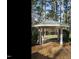 A beautifully crafted backyard gazebo sits atop a wooden deck surrounded by trees and lush greenery at 5508 Lake Edge Dr, Holly Springs, NC 27540