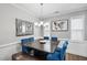 Formal dining room showcasing modern chandelier, butterfly art, and blue velvet chairs and bench at 5520 Advancing Ave, Raleigh, NC 27616