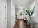 Bright foyer with hardwood floors, white trim, front door and staircase with adjacent bench at 5520 Advancing Ave, Raleigh, NC 27616