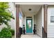 Inviting front porch with stylish teal door, craftsman columns and manicured shrubbery at 5520 Advancing Ave, Raleigh, NC 27616