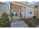 Welcoming front porch with stylish teal door, craftsman columns and well kept shrubbery at 5520 Advancing Ave, Raleigh, NC 27616